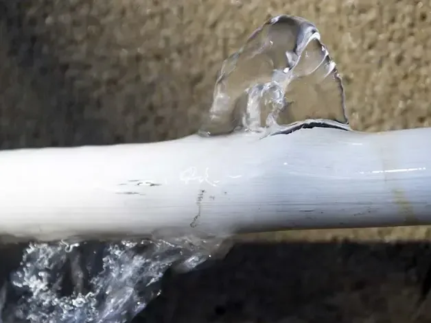 Water spraying from a split plastic supply pipe