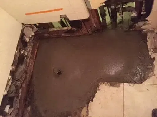 A slab floor cut open to reach a leaking supply pipe underneath
